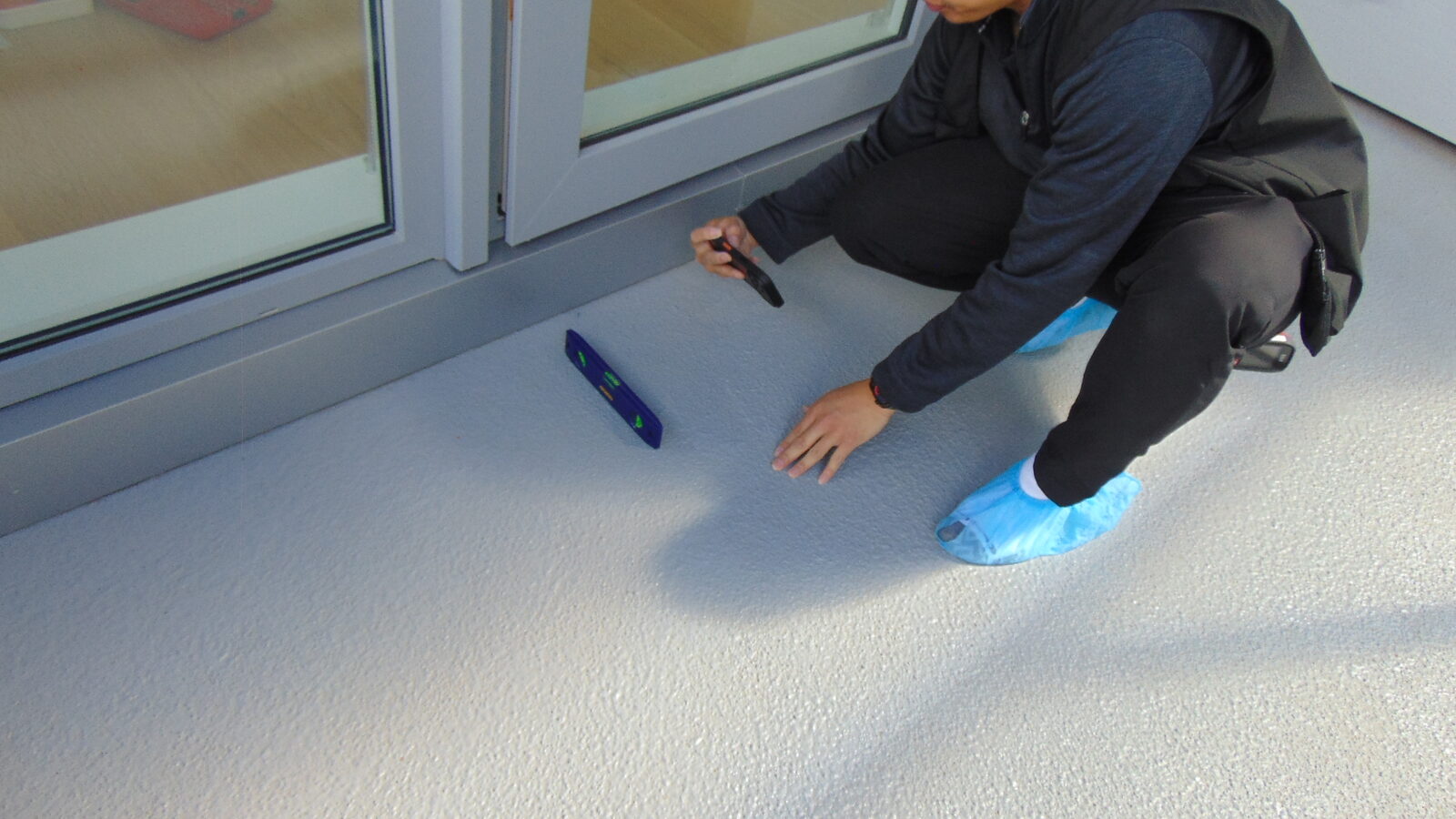 Checking balcony floor slope during an inspection